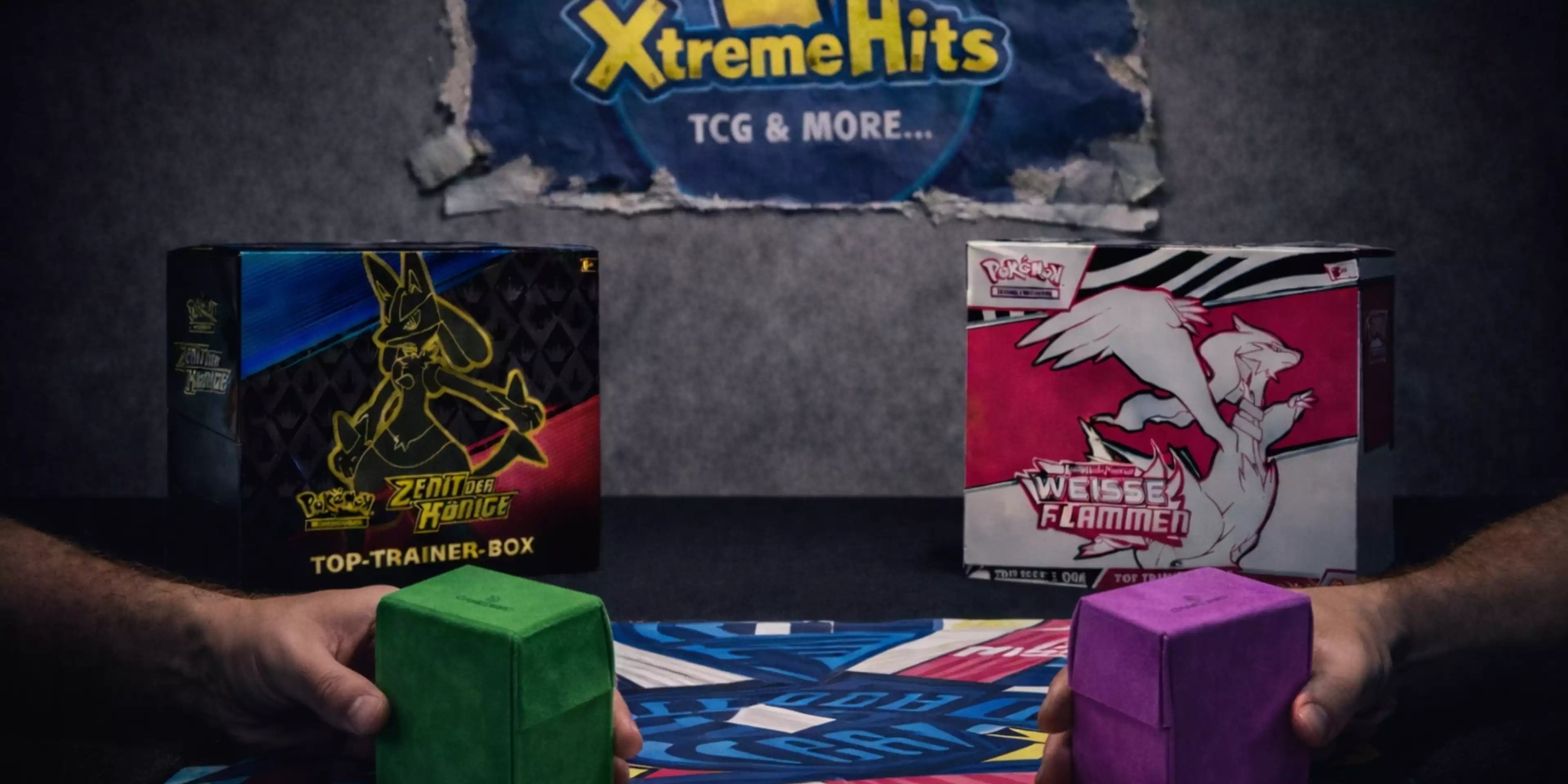 Dieses Bild ist der Startbild Banner auf der Seite Pokémon Top-Trainer Boxen vom Xtreme Hits Onlineshop.  Auf diesem Bild sind zwei Pokemon ETBs zusehen und zwei Männer die sich in einem Tradincard Match duellieren. Im Hintergrund ist das Xtreme Hits Logo als zerissendes Posterplakat zu sehen. 