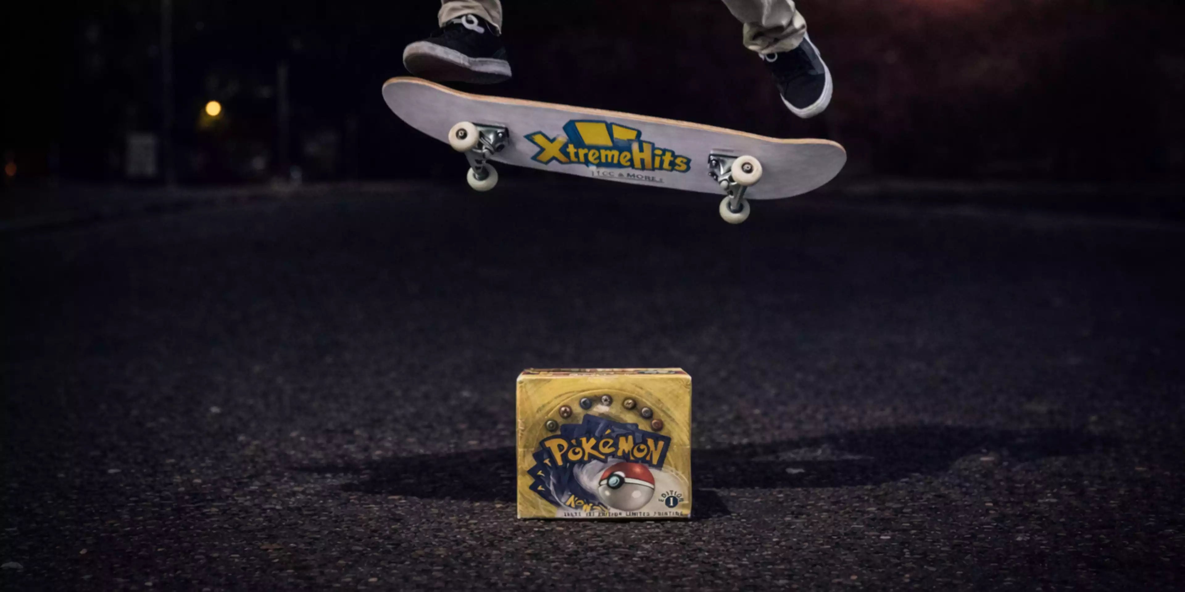 Dieses Bild ist der Startbild Banner für die Seite Pokemon Displays vom Xtreme Hits Onlineshop. Auf diesem Bild ist ein Skateboard zu sehen, dass mit einem Ollie über ein first Edition Display von Pokemon springt. Auf der Unterseite des Boards ist das Xtreme Hits Logo zu sehen.